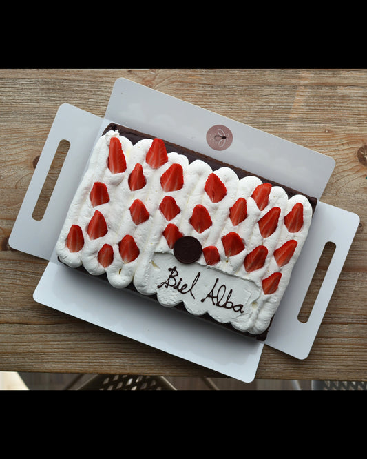 Pastel de cacao decorado de cumpleaños con nata y fresas. No contiene gluten, ni huevo ni leche. es vegano.