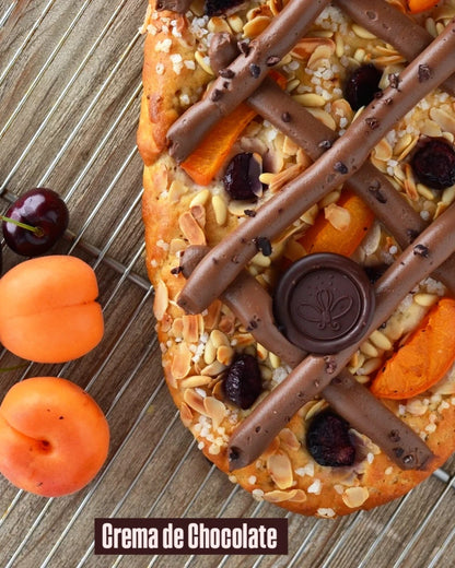 Coca sin gluten y vegana decorada con crema de chocolate y piñones