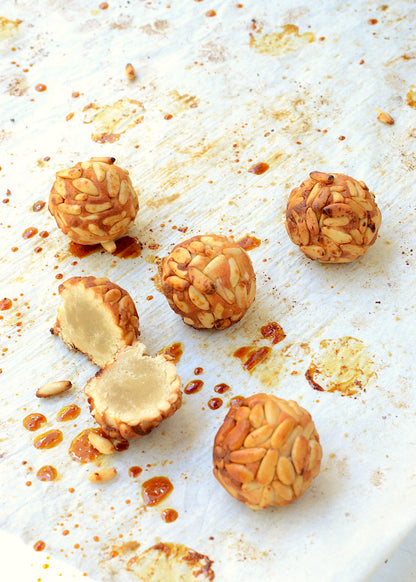 Panellet de piñón sin gluten y vegano cortado al medio para apreciar su interior.